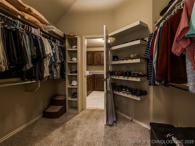 spacious closet featuring light carpet and vaulted ceiling