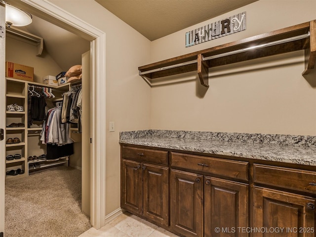 walk in closet featuring light colored carpet