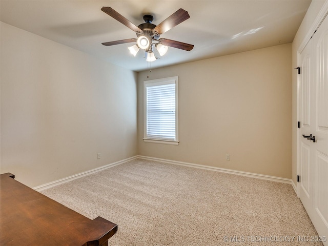 carpeted spare room featuring ceiling fan