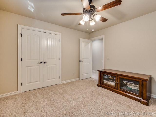 unfurnished bedroom with ceiling fan, light colored carpet, and a closet