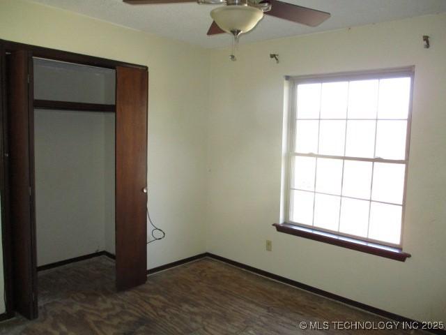 unfurnished bedroom featuring ceiling fan and a closet