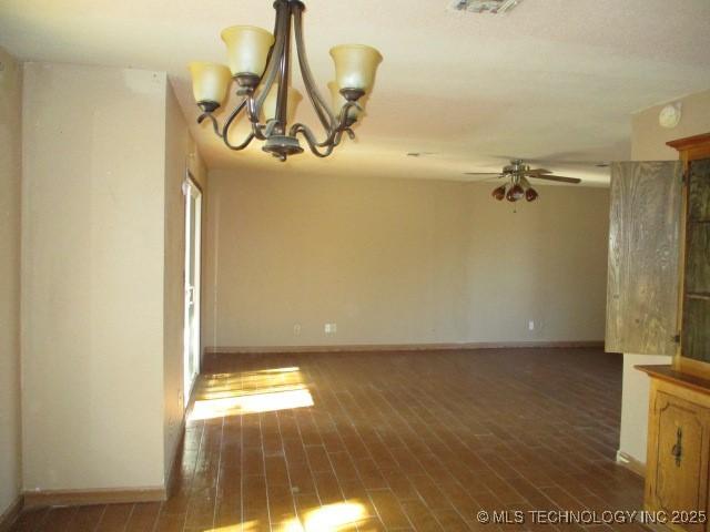 spare room with ceiling fan with notable chandelier