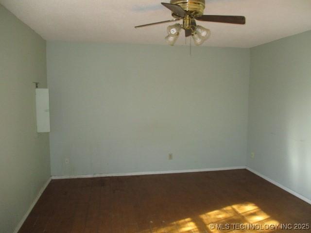 spare room with ceiling fan and dark wood-type flooring