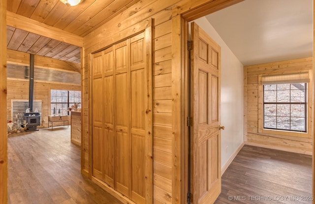 corridor featuring lofted ceiling with beams, dark hardwood / wood-style flooring, wood ceiling, and wooden walls