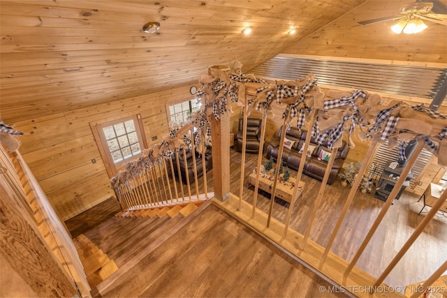 staircase with wood-type flooring, vaulted ceiling, ceiling fan, and wooden ceiling