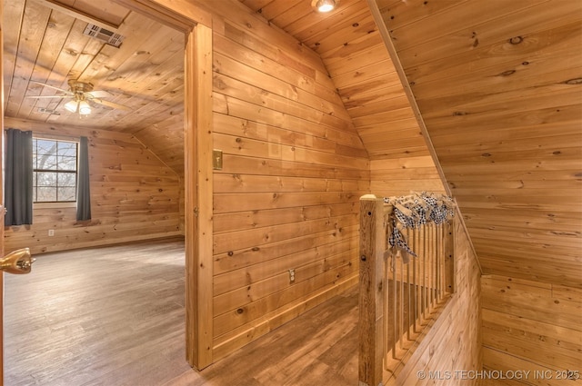 additional living space featuring wooden walls, vaulted ceiling, ceiling fan, and wooden ceiling