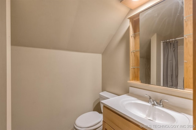 bathroom featuring toilet, vanity, vaulted ceiling, and a shower with shower curtain