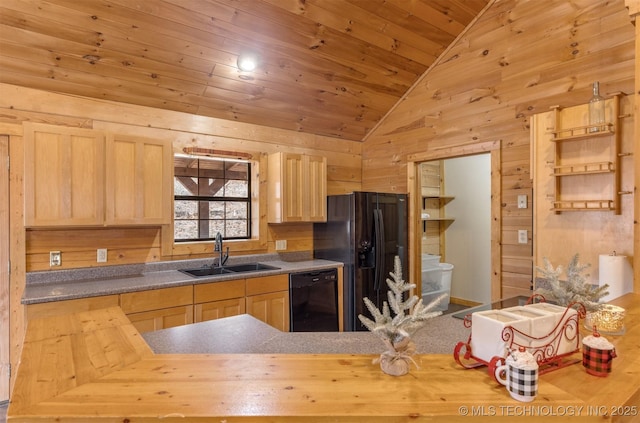 kitchen with black appliances, wood walls, sink, and light brown cabinetry