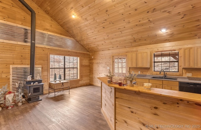 kitchen with light brown cabinetry, sink, wooden ceiling, black dishwasher, and a wood stove