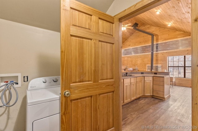 laundry room featuring light hardwood / wood-style floors, ceiling fan, wooden walls, wooden ceiling, and washer / clothes dryer