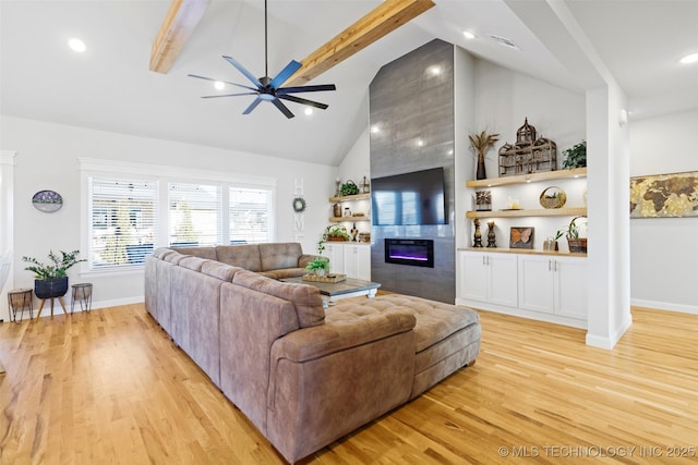 living room featuring a tile fireplace, high vaulted ceiling, ceiling fan, beam ceiling, and light hardwood / wood-style flooring