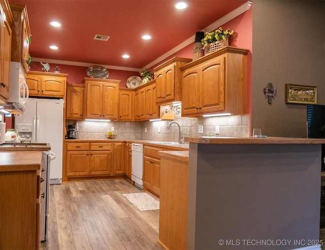 kitchen with sink, light hardwood / wood-style flooring, ornamental molding, tasteful backsplash, and kitchen peninsula