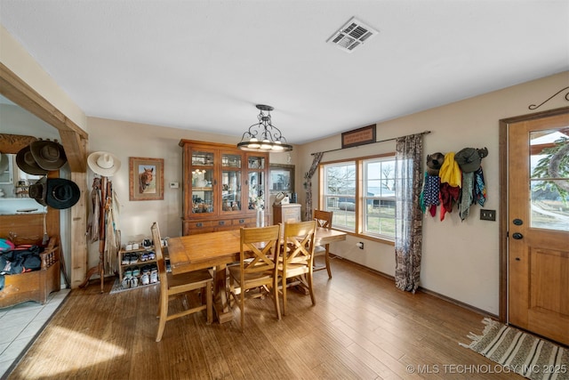 dining space featuring a notable chandelier and light wood-type flooring