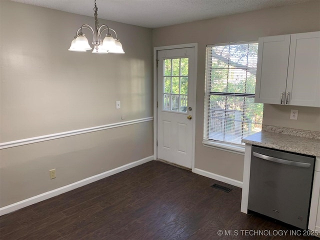 doorway to outside with a notable chandelier, dark hardwood / wood-style floors, and a textured ceiling