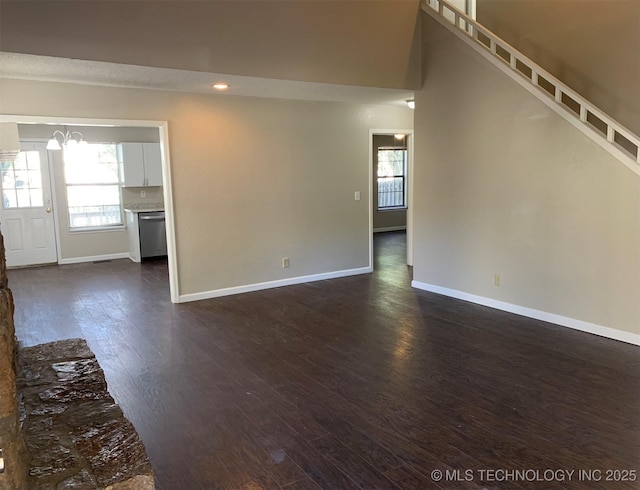 unfurnished living room with dark hardwood / wood-style flooring and a chandelier