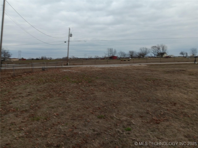 view of yard featuring a rural view and fence