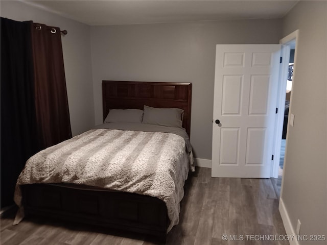 bedroom featuring wood finished floors and baseboards