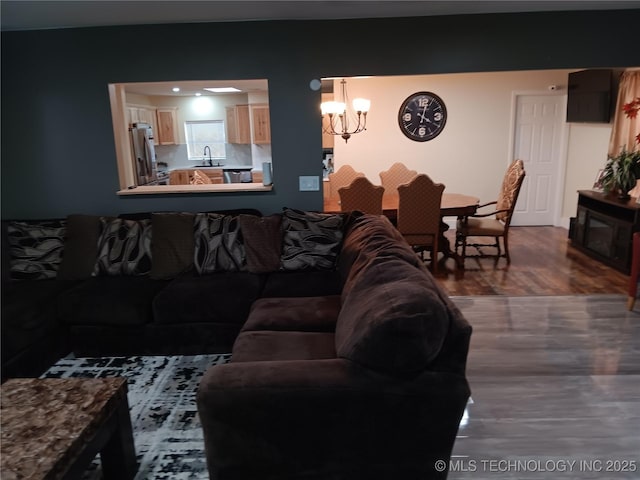 living room featuring dark wood-style flooring and an inviting chandelier