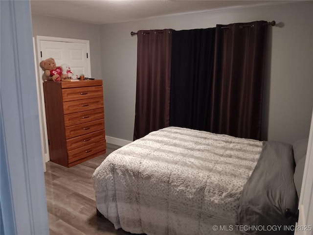 bedroom featuring baseboards and wood finished floors