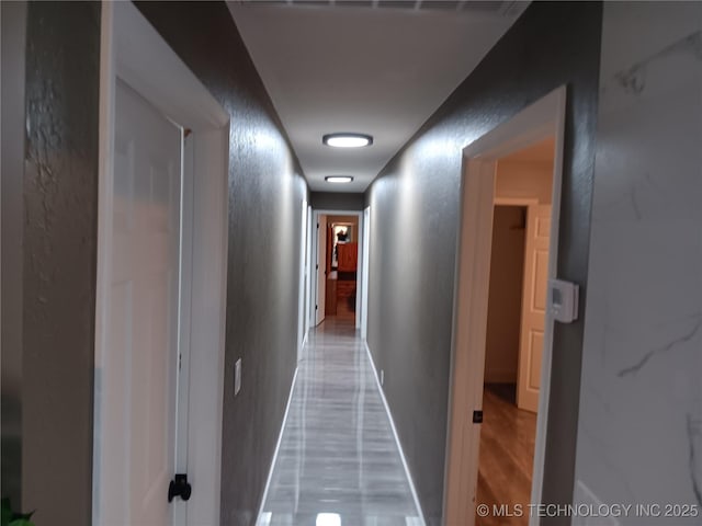 corridor with a textured wall and baseboards