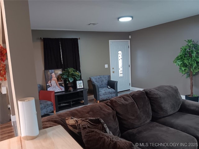 living room featuring visible vents, baseboards, and wood finished floors