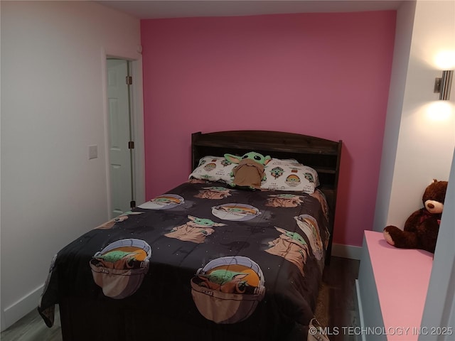 bedroom with baseboards and wood finished floors