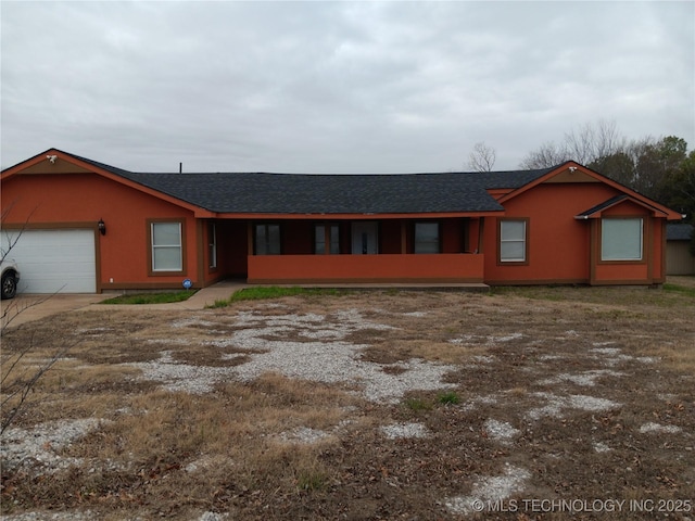 ranch-style house with a garage, stucco siding, and roof with shingles