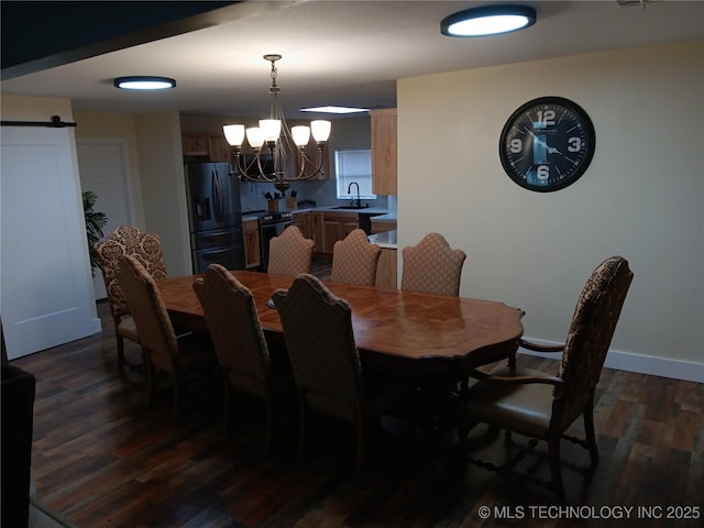 dining space featuring baseboards, a barn door, dark wood-type flooring, and a notable chandelier