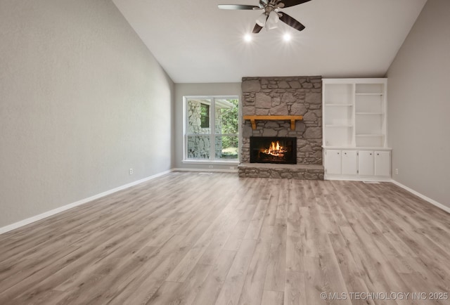 unfurnished living room featuring vaulted ceiling, ceiling fan, a fireplace, and light hardwood / wood-style floors