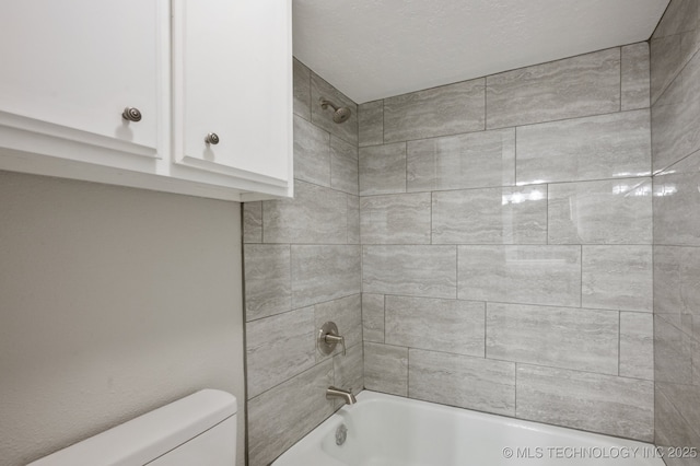 bathroom featuring tiled shower / bath and toilet