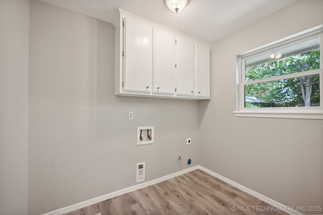 laundry area with electric dryer hookup, hookup for a washing machine, cabinets, light hardwood / wood-style floors, and hookup for a gas dryer