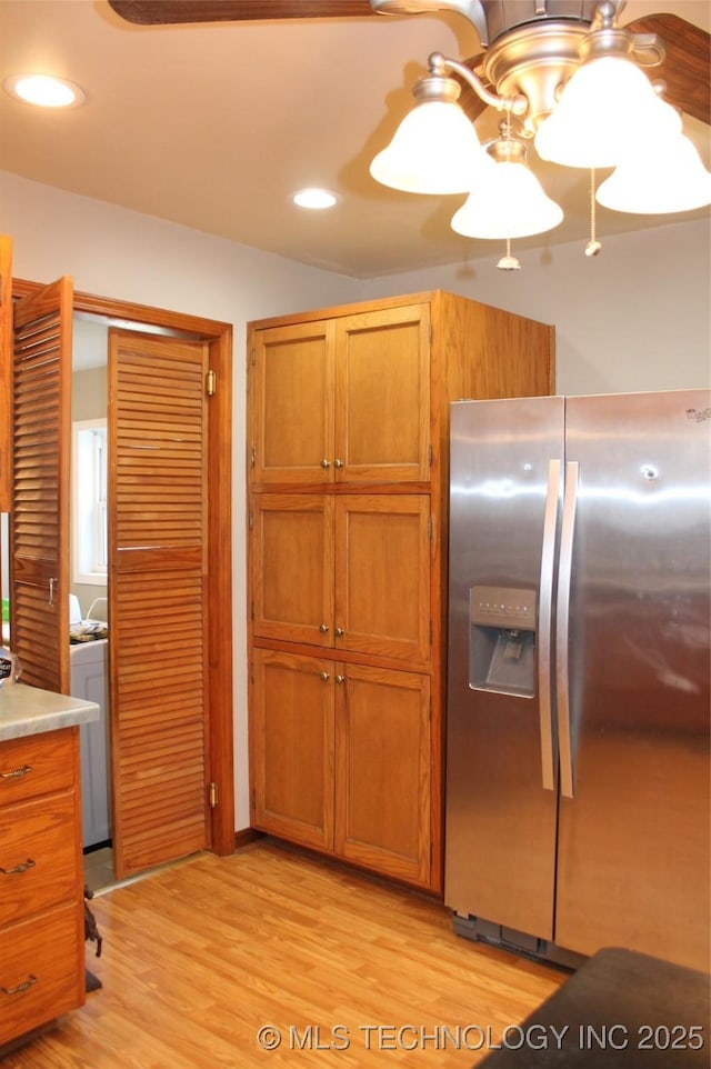 kitchen with light hardwood / wood-style floors and stainless steel refrigerator with ice dispenser