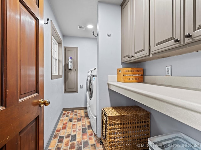 washroom with cabinets and washing machine and clothes dryer