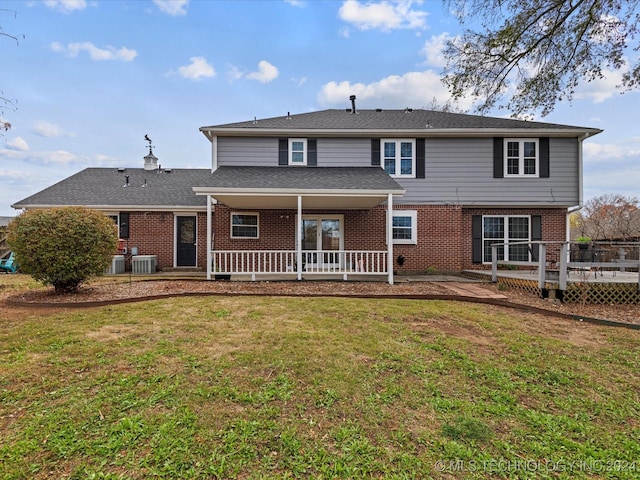 rear view of house featuring central AC, a yard, and a deck