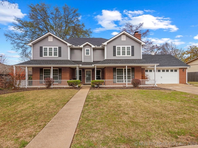 view of front of property featuring a front lawn, covered porch, and a garage