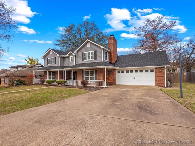 view of front of property with a front lawn, covered porch, and a garage