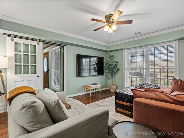 living room featuring a barn door, ceiling fan, ornamental molding, and hardwood / wood-style flooring