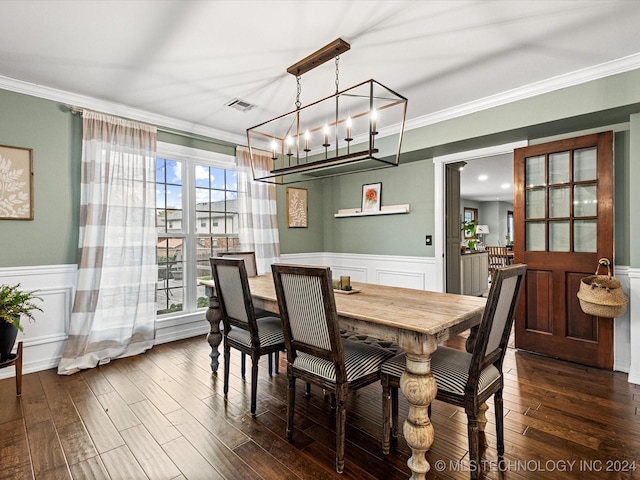 dining space featuring dark hardwood / wood-style flooring, a chandelier, and ornamental molding