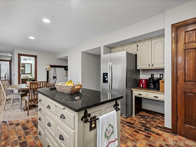 kitchen with stainless steel fridge with ice dispenser and dark stone counters