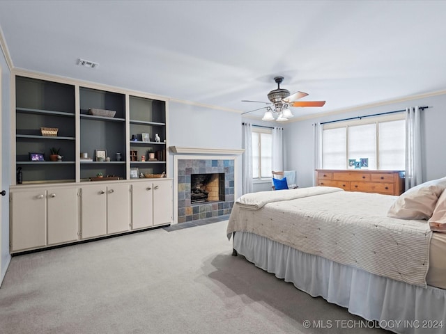 carpeted bedroom featuring ceiling fan, a fireplace, and ornamental molding