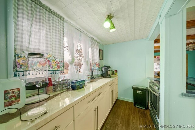 kitchen featuring white cabinets, light stone countertops, dark hardwood / wood-style flooring, and stainless steel range with electric cooktop