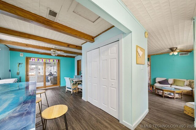 interior space featuring beamed ceiling, dark hardwood / wood-style floors, and ceiling fan