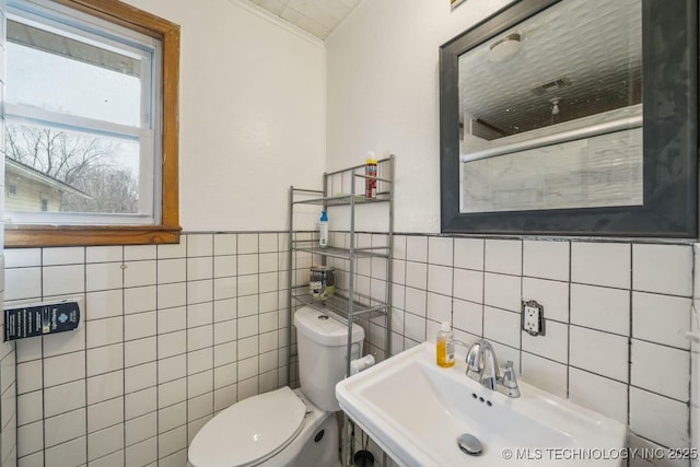 bathroom featuring crown molding, sink, tile walls, and toilet