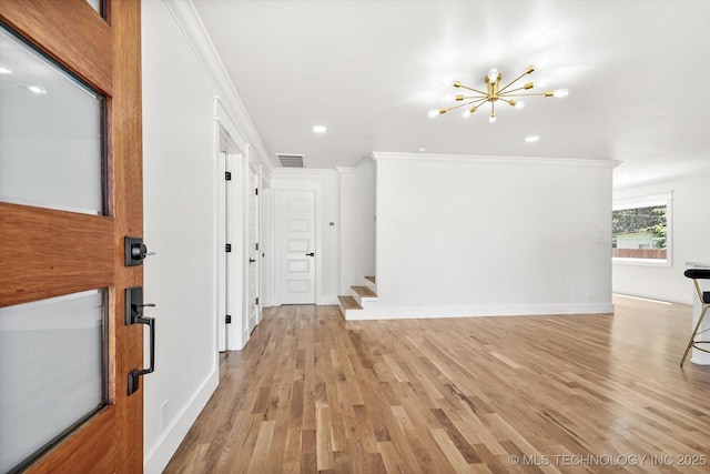 interior space featuring light wood-type flooring, ornamental molding, and a chandelier