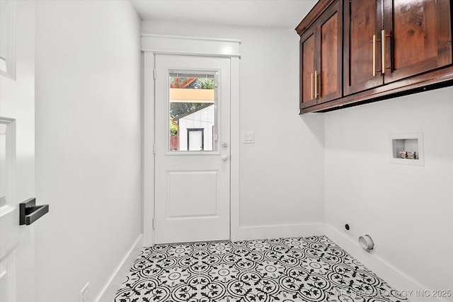 washroom featuring hookup for a washing machine, light tile patterned floors, and cabinets