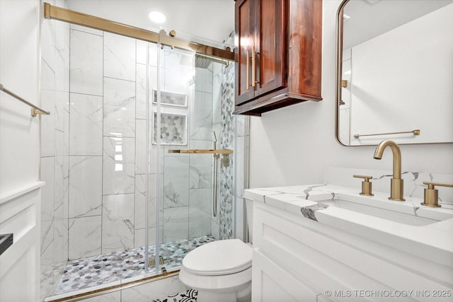 bathroom featuring toilet, vanity, and walk in shower