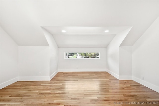 additional living space featuring light hardwood / wood-style flooring and lofted ceiling