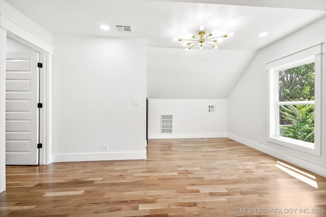 additional living space featuring a notable chandelier, light wood-type flooring, and lofted ceiling