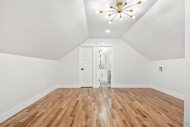 additional living space featuring a notable chandelier, light wood-type flooring, and lofted ceiling