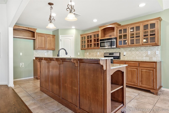 kitchen featuring decorative light fixtures, light stone countertops, stainless steel appliances, and tasteful backsplash